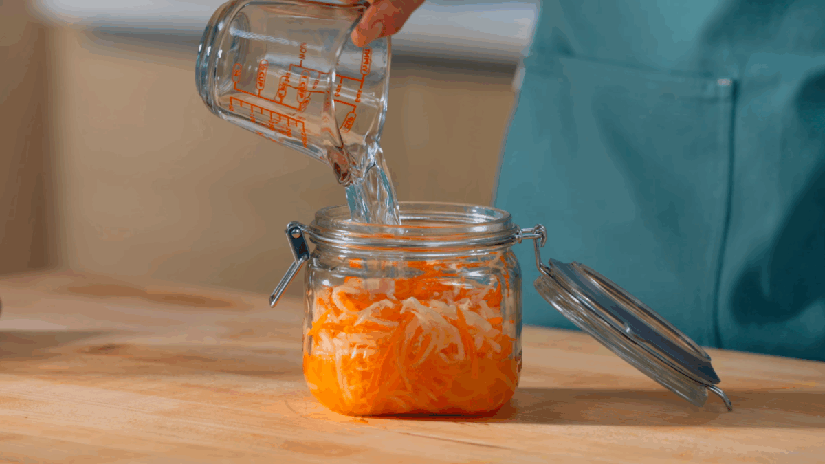 Nick DiGiovanni combining ingredients to make pickled carrots and radish in a jar.