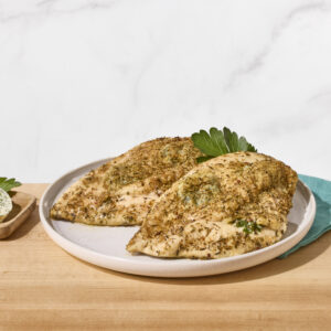 Two oven-baked chicken breasts on a plate.