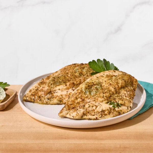 Two oven-baked chicken breasts on a plate.