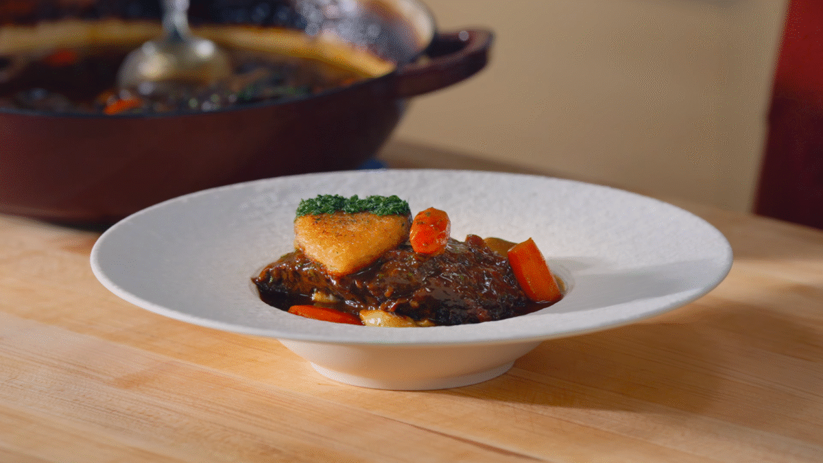 Beef bourguignon served over mashed potatoes, topped with a heart-shaped bread crouton.