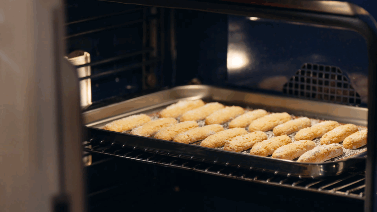 Ladyfinger biscuits baking in an oven. 