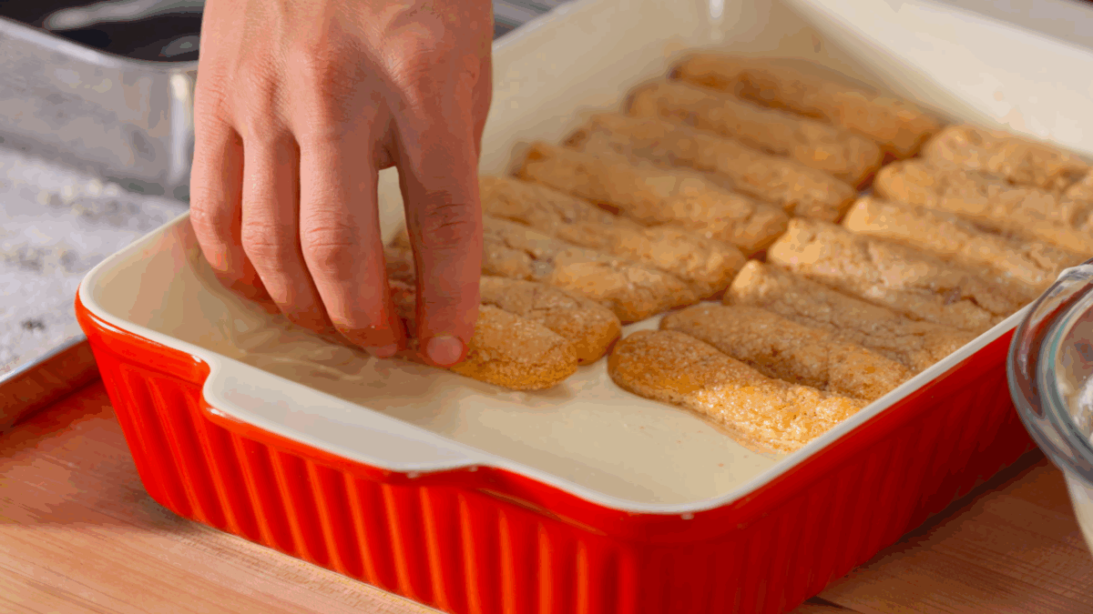 Nick DiGiovanni layering soaked ladyfingers and mascarpone filling in a baking dish. 