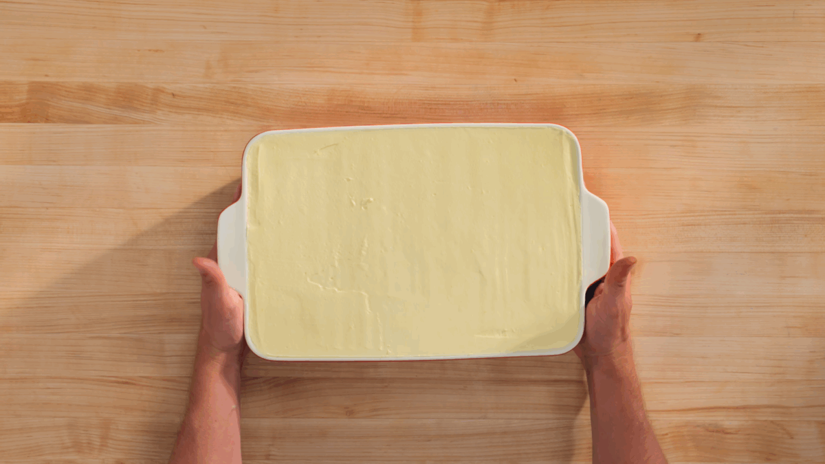 Nick DiGiovanni holding a baking dish of chilled tiramisu without a cocoa topping. 
