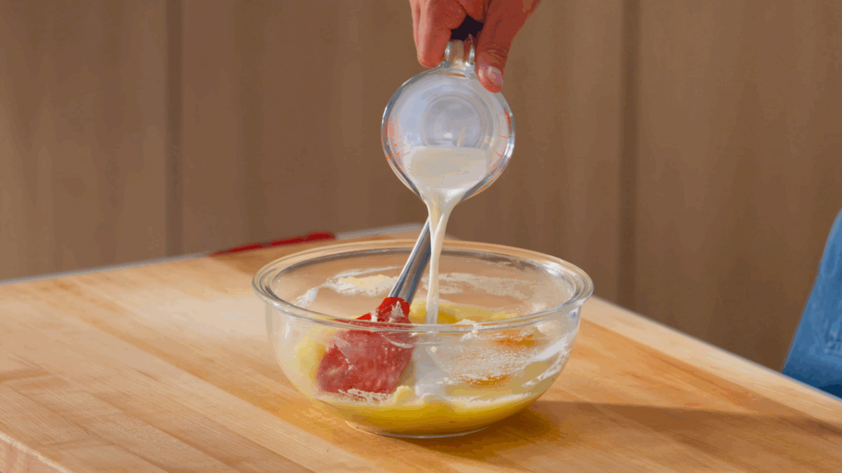 Nick DiGiovanni pouring milk into a bowl of mashed potatoes.